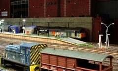 Departmental 06 shunts a brake van as 50149 with a china clay train waits the signal in the background.